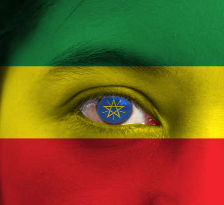 Human face painted Ethiopia flag with National Emblem on the center of eye or eyeball. Human eye painted with flag of Ethiopia.の写真素材