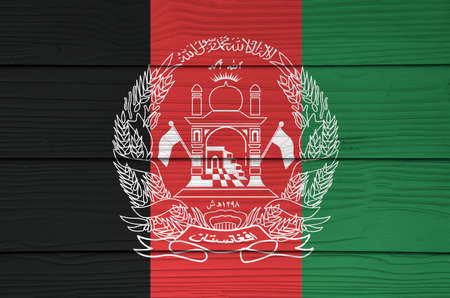 Afghanistan flag color painted on Fiber cement sheet wall background, black red and green with the National Emblem in white centered.の写真素材