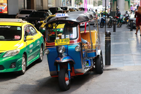 Bangkok, Thailand - Nov 27, 2019 : Taxi tricycle Tuk Tuk park to wait for passengers beside the...