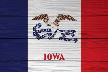 Iowa flag color painted on Fiber cement sheet wall background, vertical tricolor of blue white and red and the image of a bald eagle with a long ribbon. The states of America.の写真素材