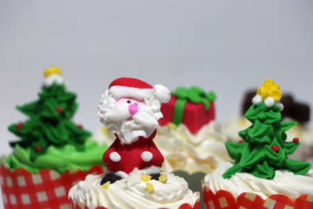 Christmas cupcakes decorated with Santa Claus and out focus Christmas cupcakes on white background. の写真素材