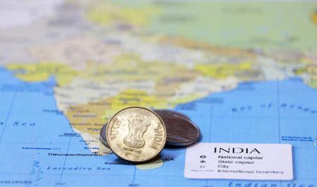 Heap of Rupee Indian money coins on the india map. Concept of money finance or travel.の写真素材