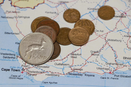 Heap of South African Rand coin money on on the map. Concept of finance or currency or travel.