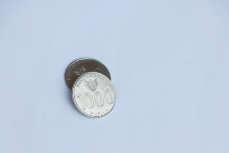 Two coins of one thousand Rupiah Indonesia money on the white background. Concept of finance or...
