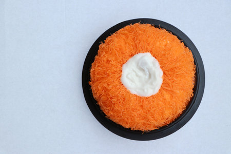 Gold Egg Yolk Thread Cakes or Foi Tong Lava Cake in the black round tray on the white floor.