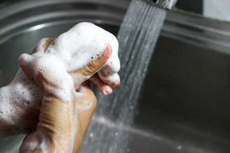 Washing hands concept. Cleaning the hands using liquid disinfectant soap under running water.