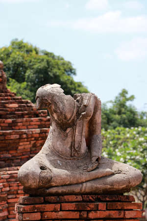 Old Buddha statue damaged without head in the midst of ruins of the Chaiwatthanaram Temple Ayutthaya, Thailand.の写真素材