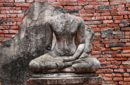 Old Buddha statue damaged without head in the midst of ruins of the Chaiwatthanaram Temple Ayutthaya, Thailand.の写真素材
