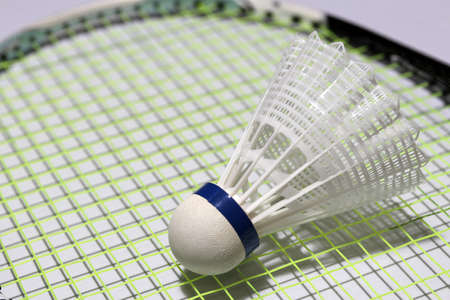 Plastic shuttlecock of badminton put on the green plastic shuttlecock of badminton put on the green net of badminton racket. it is a cork to which feathers are attached to form a cone shape.の写真素材