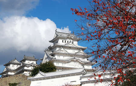 Himeji, Hyogo, Kansai, Japan November 19, 2017: White Himeji Castle on the sunlight and foreground red leaves on the tree  with blue sky background. Himeji Castle also known as White Heron Castle.のeditorial素材