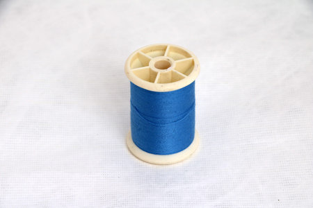 Thread tube with blue isolate on white background, Vertical top view. Its is a garment accessories.