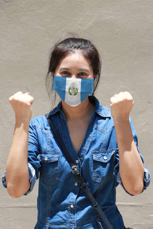 Guatemala flag on hygienic mask. Masked woman prevent germs and wear denim dress. Tiny Particle or virus corona or Covid 19 protection. Concept of Combating illness.の写真素材