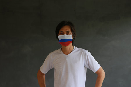 Masked man prevent germs with Russia flag pattern mask and wear white shirt. Tiny Particle or virus corona or Covid 19 protection.の写真素材
