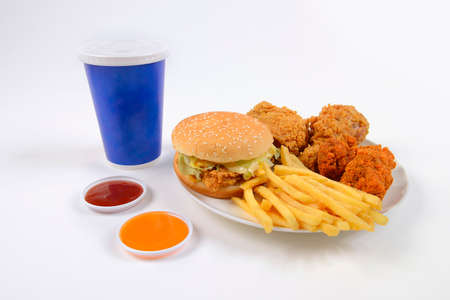 Fast food set containing burgers, fried chicken, french fries and soft drink isolated on white background.の写真素材