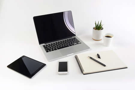 Office table with laptop computer, notebook, digital tablet and smartphone on white background.の写真素材