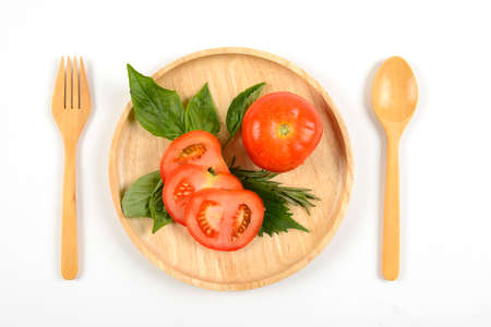 Fresh raw tomatoes on wood dish for healthy isolated background.(clean eating dieting and healthy organic food concept)の写真素材