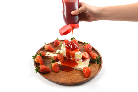 Topped with jam strawberry on strawberry cake on white background.の写真素材