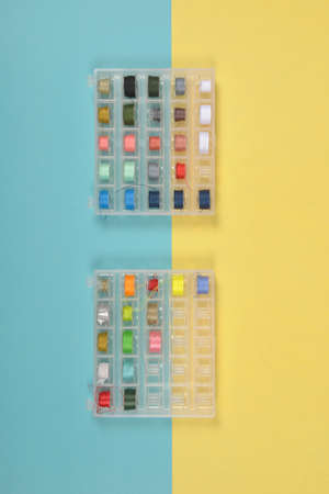 Flat lay of colored thread rolls for sewing on two tone background, Sewing and needlework concept.の写真素材