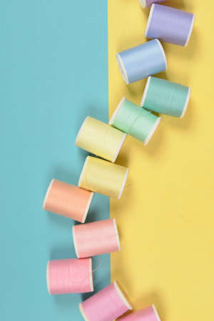 Flat lay of colored thread rolls for sewing on two tone background, Sewing and needlework concept.の写真素材