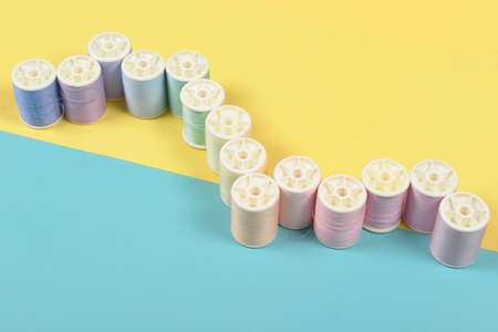 Flat lay of colored thread rolls for sewing on two tone background, Sewing and needlework concept.の写真素材