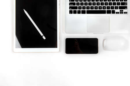 Office table with laptop computer, digital tablet, smartphone, pencil and mouse on isolated pure white background / Laptop and tablet mockup concept. (Selective Focus)の写真素材