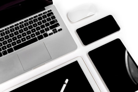Office table with laptop computer, digital tablet, smartphone, pencil and mouse on isolated pure...