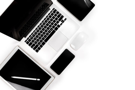 Office table with laptop computer, digital tablet, smartphone, pencil and mouse on isolated pure...