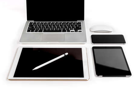 Office table with laptop computer, digital tablet, smartphone, pencil and mouse on isolated pure white background / Laptop and tablet mockup concept. (Selective Focus)の写真素材