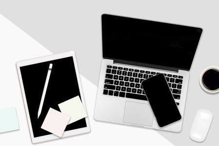 Flat lay office table with laptop computer, digital tablet, mobile phone and accessories on two tone...