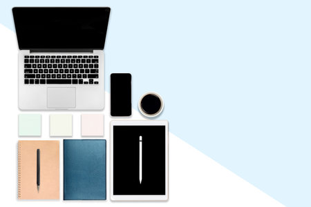 Flat lay photo of office table with laptop computer, digital tablet, mobile phone and accessories....