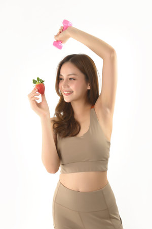 Pretty asian woman with dumbbell and strawberry on white background.