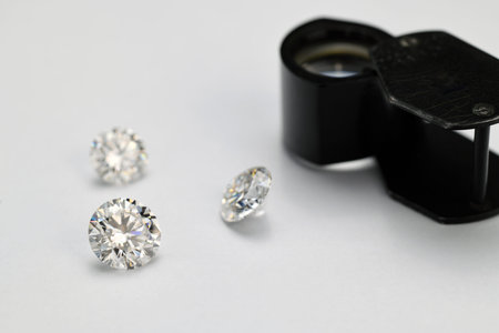 Luxury Diamonds and Magnification Loupe on White Background