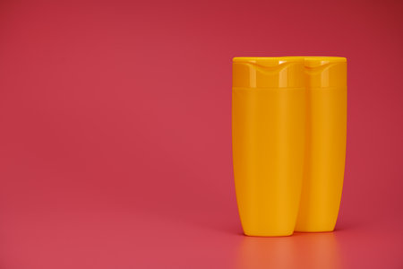 Blank Label Shampoo Yellow Bottles or Shower Gel on Pink Backgroundの写真素材