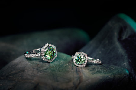 jewelry ring with green gemstones on a dark background.の写真素材