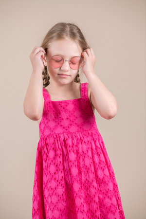 Portrait of a cute little girl in a pink dress and sunglassesの写真素材