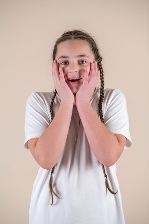 Portrait of a young girl with braids on a beige backgroundの写真素材