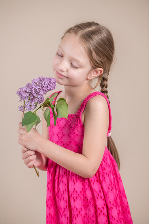 Little girl with a bouquet of lilacs in her hands.の写真素材