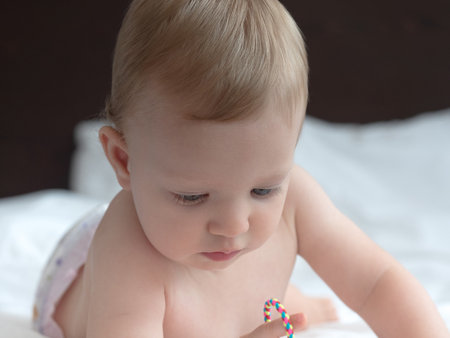 Portrait of a cute baby girl on the bed at home.の写真素材