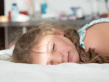 Little girl sleeping on the bed in the morning. Selective focus.の写真素材