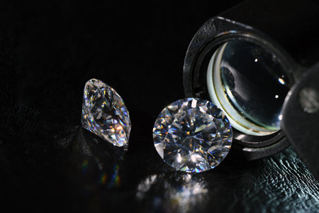 Brilliant diamonds on a black background with a magnifying glassの写真素材