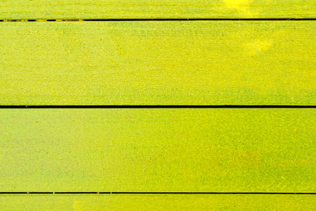 A yellow wooden board with a green stripe. The board is made of wood and has a green stripe on itの写真素材