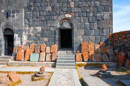 A Sevan Monastery Sevanavank with a large archway and a pile of rocks in front of it. The building...