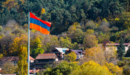 Armenian flag flying in the air. The flag is orange blue and red. The image has a peaceful and serene moodの写真素材