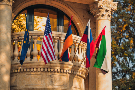 Yerevan Armenia 11.20.2025. A group of flags are hanging from a balcony, including the American flag. The flags are of different colors and sizes, and they are arranged in a way that creates a sense of unity and diversityのeditorial素材