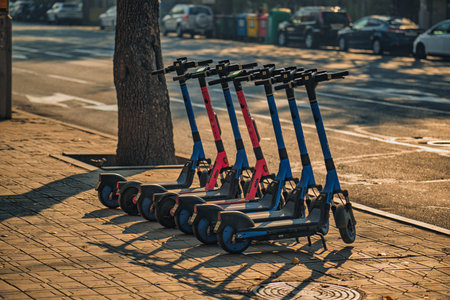 Yerevan Armenia 11.20.2025. A row of scooters are lined up on the sidewalk. The scooters are blue and redの写真素材