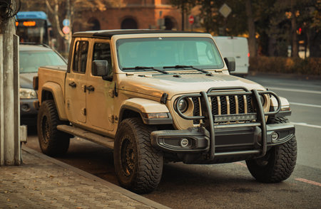 Yerevan Armenia 11.20.2025. A tan jeep is parked on the side of the road. The jeep is parked next to...