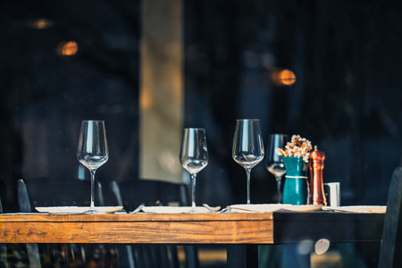 A table with four wine glasses and a salt and pepper shaker. The table is set for a mealのeditorial素材