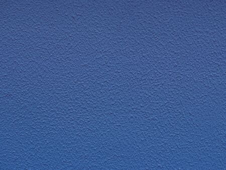 Blue backdrop with ornament.. Paper texture. Dark blue stucco surface. Concrete wall. Abstract pattern, embossed background. Texture of paint on grooved plaster.の写真素材