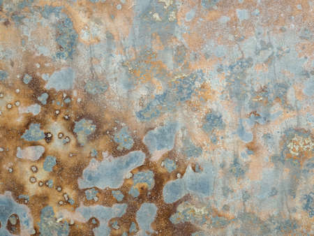 Corroded metal background. Texture of oxidized metal with brass and aqua patina. Rusty metal surface with streaks of rust. Rusty corrosion. Brown, grey, blue and orange rust and dirt on enamel.の写真素材