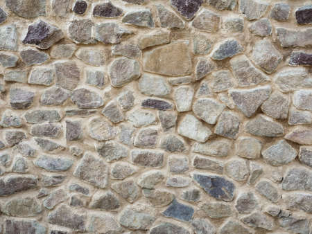 Stone wall. Texture of grey granite. Uneven rock surface of floor, decorative tile of facade building. Mosaic pattern of stones, cementの写真素材